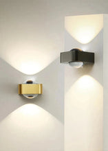 Load image into Gallery viewer, Inspira Lifestyles | Chiaro Wall Sconce with clear glass globe and minimalist Italian design, black/gold/white finish, featuring soft ambient up-and-down LED lighting, ideal for modern living rooms, bedrooms, hallways, and commercial interiors.