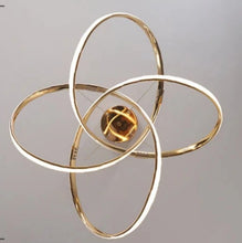 Load image into Gallery viewer, INSPIRA LIFESTYLES | Helia Twisted Pendant Light in chrome, polished gold, and matte black finishes, featuring a sculptural ribbon-like design, suspended with near-invisible wires to create a floating effect, perfect for modern interiors, dining rooms, stairwells, and contemporary living spaces, stylish lighting fixture, luxury pendant light, ambient illumination, contemporary ceiling lighting. Modern Chandelier, Minimalist Chandelier, Sculptural light, Dining table light, Living room light, LED Pendant