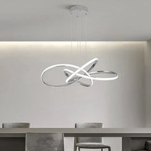 Load image into Gallery viewer, INSPIRA LIFESTYLES | Helia Twisted Pendant Light in chrome, polished gold, and matte black finishes, featuring a sculptural ribbon-like design, suspended with near-invisible wires to create a floating effect, perfect for modern interiors, dining rooms, stairwells, and contemporary living spaces, stylish lighting fixture, luxury pendant light, ambient illumination, contemporary ceiling lighting. Modern Chandelier, Minimalist Chandelier, Sculptural light, Dining table light, Living room light, LED Pendant