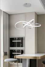 Load image into Gallery viewer, INSPIRA LIFESTYLES | Helia Twisted Pendant Light in chrome, polished gold, and matte black finishes, featuring a sculptural ribbon-like design, suspended with near-invisible wires to create a floating effect, perfect for modern interiors, dining rooms, stairwells, and contemporary living spaces, stylish lighting fixture, luxury pendant light, ambient illumination, contemporary ceiling lighting. Modern Chandelier, Minimalist Chandelier, Sculptural light, Dining table light, Living room light, LED Pendant