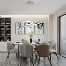 Load image into Gallery viewer, INSPIRA LIFESTYLES | Helia Twisted Pendant Light in chrome, polished gold, and matte black finishes, featuring a sculptural ribbon-like design, suspended with near-invisible wires to create a floating effect, perfect for modern interiors, dining rooms, stairwells, and contemporary living spaces, stylish lighting fixture, luxury pendant light, ambient illumination, contemporary ceiling lighting. Modern Chandelier, Minimalist Chandelier, Sculptural light, Dining table light, Living room light, LED Pendant