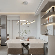 Load image into Gallery viewer, INSPIRA LIFESTYLES | Helia Twisted Pendant Light in chrome, polished gold, and matte black finishes, featuring a sculptural ribbon-like design, suspended with near-invisible wires to create a floating effect, perfect for modern interiors, dining rooms, stairwells, and contemporary living spaces, stylish lighting fixture, luxury pendant light, ambient illumination, contemporary ceiling lighting. Modern Chandelier, Minimalist Chandelier, Sculptural light, Dining table light, Living room light, LED Pendant