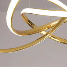 Load image into Gallery viewer, INSPIRA LIFESTYLES | Helia Twisted Pendant Light in chrome, polished gold, and matte black finishes, featuring a sculptural ribbon-like design, suspended with near-invisible wires to create a floating effect, perfect for modern interiors, dining rooms, stairwells, and contemporary living spaces, stylish lighting fixture, luxury pendant light, ambient illumination, contemporary ceiling lighting. Modern Chandelier, Minimalist Chandelier, Sculptural light, Dining table light, Living room light, LED Pendant