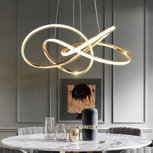 Load image into Gallery viewer, INSPIRA LIFESTYLES | Helia Twisted Pendant Light in chrome, polished gold, and matte black finishes, featuring a sculptural ribbon-like design, suspended with near-invisible wires to create a floating effect, perfect for modern interiors, dining rooms, stairwells, and contemporary living spaces, stylish lighting fixture, luxury pendant light, ambient illumination, contemporary ceiling lighting. Modern Chandelier, Minimalist Chandelier, Sculptural light, Dining table light, Living room light, LED Pendant
