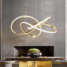 Load image into Gallery viewer, INSPIRA LIFESTYLES | Helia Twisted Pendant Light in chrome, polished gold, and matte black finishes, featuring a sculptural ribbon-like design, suspended with near-invisible wires to create a floating effect, perfect for modern interiors, dining rooms, stairwells, and contemporary living spaces, stylish lighting fixture, luxury pendant light, ambient illumination, contemporary ceiling lighting. Modern Chandelier, Minimalist Chandelier, Sculptural light, Dining table light, Living room light, LED Pendant