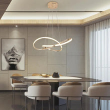 Load image into Gallery viewer, INSPIRA LIFESTYLES | Helia Twisted Pendant Light in chrome, polished gold, and matte black finishes, featuring a sculptural ribbon-like design, suspended with near-invisible wires to create a floating effect, perfect for modern interiors, dining rooms, stairwells, and contemporary living spaces, stylish lighting fixture, luxury pendant light, ambient illumination, contemporary ceiling lighting. Modern Chandelier, Minimalist Chandelier, Sculptural light, Dining table light, Living room light, LED Pendant