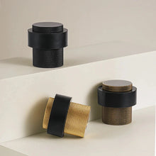 Load image into Gallery viewer, INSPIRA LIFESTYLES - Knurled Floor Door Stops featuring a crisscross diamond knurled pattern and protective rubber bumpers in Matte Black, Satin Brass and Antique Bronze.