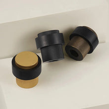 Load image into Gallery viewer, INSPIRA LIFESTYLES - Knurled Floor Door Stops featuring a crisscross diamond knurled pattern and protective rubber bumpers in Matte Black, Satin Brass and Antique Bronze.