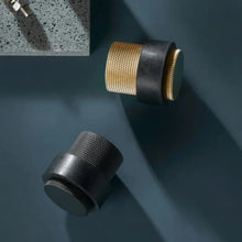 Load image into Gallery viewer, INSPIRA LIFESTYLES - Knurled Floor Door Stops featuring a crisscross diamond knurled pattern and protective rubber bumpers in Matte Black, Satin Brass and Antique Bronze.