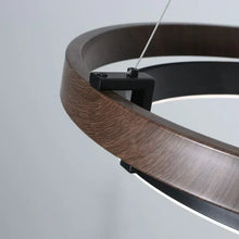 Load image into Gallery viewer, INSPIRA LIFESTYLES – Anello Duo Chandelier – sculptural two-tier chandelier with wood-patterned ring and matte black ring. Modern LED light fixture for dining rooms, living rooms, stairwells, offices, and transitional interiors.