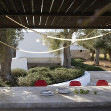 Load image into Gallery viewer, Siliq Sculptural Light with handcrafted silicone forms and metallic segmented cables, single minimalist pendant with glowing silicone tube, dramatic chandelier version of Siliq Light for high ceilings, floor-to-ceiling sculptural lighting installation in modern interior, flexible silicone light tubes emitting soft ambient glow, artistic designer light fixture styled in dining room, contemporary sculptural lighting as statement piece in commercial space.