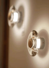 Load image into Gallery viewer, Inspira Lifestyles | Onda Crystal Wall Light with round optical crystal disc and chrome center, mounted as a modern LED wall or ceiling sconce.
