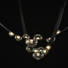 Load image into Gallery viewer, INSPIRA LIFESTYLES - Strapped Chandelier - ABSTRACT LIGHT, ACCENT LIGHT, BEDROOM LIGHT, BOARDROOM LIGHT, CHANDELIER, DINING LIGHT, FEATURE LIGHT, GLASS GLOBE CHANDELIER, GLOBE CHANDELIER, GLOBE LIGHT, HANGING LIGHT, HOTEL LIGHT, LEATHER STRAP LIGHT, LED CHANDELIER, LED LIGHT, LIGHT, LIGHT FIXTURE, LIGHTING, LIGHTS, LIVING ROOM LIGHT, MINIMAL LIGHT FIXTURE, MINIMALIST CHANDELIER, MINIMALIST LIGHT, MODERN CHANDELIER, MODERN LIGHT, MODERN PENDANT LIGHT, PENDANT LIGHT, RESTAURANT LIGHT, SCULPTURAL LIGHT
