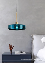 Load image into Gallery viewer, INSPIRA LIFESTYLES - Azura Blue Glass Pendant featuring translucent circular blue glass, modern sculptural pendant lighting with minimalist architectural design, ambient blue glass pendant for dining rooms, kitchen islands, bedrooms, living rooms, entryways, restaurants, boutique hotels, and luxury contemporary interiors
