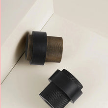 Load image into Gallery viewer, INSPIRA LIFESTYLES - Knurled Floor Door Stops featuring a crisscross diamond knurled pattern and protective rubber bumpers in Matte Black, Satin Brass and Antique Bronze.
