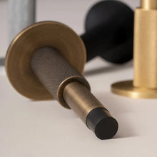 Load image into Gallery viewer, INSPIRA LIFESTYLES - Knurled Wall Door Stops with crisscross diamond-pattern detailing, adjustable length and rubber cushion pads in Matte Black, Satin Brass, Bright Chrome and Antique Bronze.
