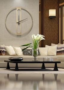 INSPIRA LIFESTYLES - Xavier Wall Clock, extra large wall clock, modern iron wall clock, sculptural wall decor, gold wall clock, charcoal wall clock, minimalist timepiece, statement wall accent, living room clock, office wall clock, oversized modern clock. Modern living room with a clock on the wall, a sofa, and a coffee table.