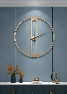 INSPIRA LIFESTYLES - Xavier Wall Clock, extra large wall clock, modern iron wall clock, sculptural wall decor, gold wall clock, charcoal wall clock, minimalist timepiece, statement wall accent, living room clock, office wall clock, oversized modern clock Modern wall clock on a blue wall with decorative items below.