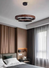 Load image into Gallery viewer, INSPIRA LIFESTYLES – Anello Duo Chandelier – sculptural two-tier chandelier with wood-patterned ring and matte black ring. Modern LED light fixture for dining rooms, living rooms, stairwells, offices, and transitional interiors.
