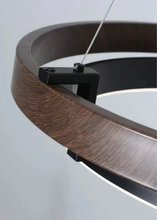 Load image into Gallery viewer, INSPIRA LIFESTYLES – Anello Duo Chandelier – sculptural two-tier chandelier with wood-patterned ring and matte black ring. Modern LED light fixture for dining rooms, living rooms, stairwells, offices, and transitional interiors.
