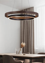 Load image into Gallery viewer, INSPIRA LIFESTYLES – Anello Duo Chandelier – sculptural two-tier chandelier with wood-patterned ring and matte black ring. Modern LED light fixture for dining rooms, living rooms, stairwells, offices, and transitional interiors.
