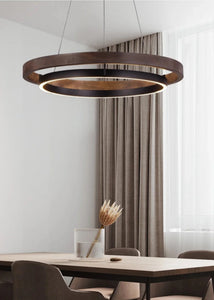 INSPIRA LIFESTYLES – Anello Duo Chandelier – sculptural two-tier chandelier with wood-patterned ring and matte black ring. Modern LED light fixture for dining rooms, living rooms, stairwells, offices, and transitional interiors.