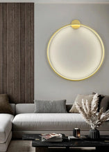 Load image into Gallery viewer, INSPIRA LIFESTYLES – Minimalist Metal Ring Light, a modern circular LED wall light with sleek sculptural design. This versatile wall sconce doubles as accent lighting and wall art, perfect as a bedroom light above a headboard, a living room statement piece, or a minimalist hallway fixture. Contemporary ring light crafted in metal with soft LED illumination, ideal for modern interiors seeking sculptural lighting, circle lights, or functional yet artistic wall sconces.

