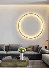 Load image into Gallery viewer, INSPIRA LIFESTYLES – Minimalist Metal Ring Light, a modern circular LED wall light with sleek sculptural design. This versatile wall sconce doubles as accent lighting and wall art, perfect as a bedroom light above a headboard, a living room statement piece, or a minimalist hallway fixture. Contemporary ring light crafted in metal with soft LED illumination, ideal for modern interiors seeking sculptural lighting, circle lights, or functional yet artistic wall sconces.
