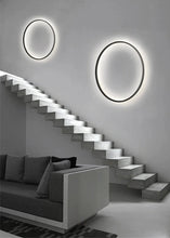 Load image into Gallery viewer, INSPIRA LIFESTYLES – Minimalist Metal Ring Light, a modern circular LED wall light with sleek sculptural design. This versatile wall sconce doubles as accent lighting and wall art, perfect as a bedroom light above a headboard, a living room statement piece, or a minimalist hallway fixture. Contemporary ring light crafted in metal with soft LED illumination, ideal for modern interiors seeking sculptural lighting, circle lights, or functional yet artistic wall sconces.
