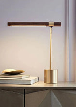 Load image into Gallery viewer, INSPIRA LIFESTYLES – Postaro Table Lamp – modern LED table lamp with postmodern design, featuring a dark wood base and satin brass accents. Sculptural yet functional lighting with a 90-degree adjustable tilt, perfect for bedside tables, home offices, and contemporary workspaces.
