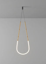 Load image into Gallery viewer, Siliq Sculptural Light with handcrafted silicone forms and metallic segmented cables, single minimalist pendant with glowing silicone tube, dramatic chandelier version of Siliq Light for high ceilings, floor-to-ceiling sculptural lighting installation in modern interior, flexible silicone light tubes emitting soft ambient glow, artistic designer light fixture styled in dining room, contemporary sculptural lighting as statement piece in commercial space.

