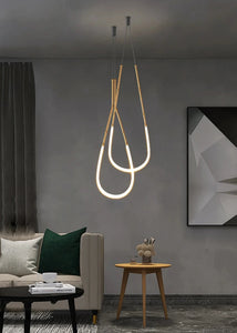 Siliq Sculptural Light with handcrafted silicone forms and metallic segmented cables, single minimalist pendant with glowing silicone tube, dramatic chandelier version of Siliq Light for high ceilings, floor-to-ceiling sculptural lighting installation in modern interior, flexible silicone light tubes emitting soft ambient glow, artistic designer light fixture styled in dining room, contemporary sculptural lighting as statement piece in commercial space.