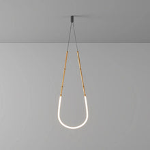 Load image into Gallery viewer, Siliq Sculptural Light with handcrafted silicone forms and metallic segmented cables, single minimalist pendant with glowing silicone tube, dramatic chandelier version of Siliq Light for high ceilings, floor-to-ceiling sculptural lighting installation in modern interior, flexible silicone light tubes emitting soft ambient glow, artistic designer light fixture styled in dining room, contemporary sculptural lighting as statement piece in commercial space.
