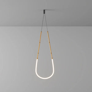 Siliq Sculptural Light with handcrafted silicone forms and metallic segmented cables, single minimalist pendant with glowing silicone tube, dramatic chandelier version of Siliq Light for high ceilings, floor-to-ceiling sculptural lighting installation in modern interior, flexible silicone light tubes emitting soft ambient glow, artistic designer light fixture styled in dining room, contemporary sculptural lighting as statement piece in commercial space.