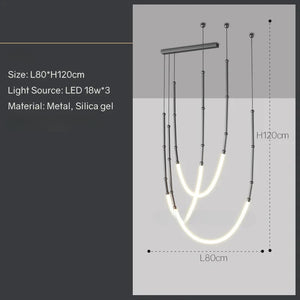 Siliq Sculptural Light with handcrafted silicone forms and metallic segmented cables, single minimalist pendant with glowing silicone tube, dramatic chandelier version of Siliq Light for high ceilings, floor-to-ceiling sculptural lighting installation in modern interior, flexible silicone light tubes emitting soft ambient glow, artistic designer light fixture styled in dining room, contemporary sculptural lighting as statement piece in commercial space.