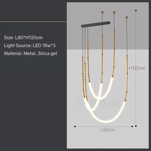 Siliq Sculptural Light with handcrafted silicone forms and metallic segmented cables, single minimalist pendant with glowing silicone tube, dramatic chandelier version of Siliq Light for high ceilings, floor-to-ceiling sculptural lighting installation in modern interior, flexible silicone light tubes emitting soft ambient glow, artistic designer light fixture styled in dining room, contemporary sculptural lighting as statement piece in commercial space.