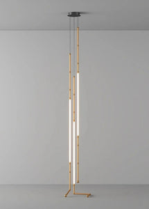 Siliq Sculptural Light with handcrafted silicone forms and metallic segmented cables, single minimalist pendant with glowing silicone tube, dramatic chandelier version of Siliq Light for high ceilings, floor-to-ceiling sculptural lighting installation in modern interior, flexible silicone light tubes emitting soft ambient glow, artistic designer light fixture styled in dining room, contemporary sculptural lighting as statement piece in commercial space.