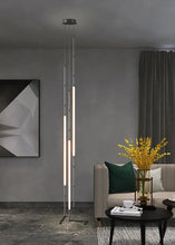 Load image into Gallery viewer, Siliq Sculptural Light with handcrafted silicone forms and metallic segmented cables, single minimalist pendant with glowing silicone tube, dramatic chandelier version of Siliq Light for high ceilings, floor-to-ceiling sculptural lighting installation in modern interior, flexible silicone light tubes emitting soft ambient glow, artistic designer light fixture styled in dining room, contemporary sculptural lighting as statement piece in commercial space.
