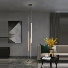 Load image into Gallery viewer, Siliq Sculptural Light with handcrafted silicone forms and metallic segmented cables, single minimalist pendant with glowing silicone tube, dramatic chandelier version of Siliq Light for high ceilings, floor-to-ceiling sculptural lighting installation in modern interior, flexible silicone light tubes emitting soft ambient glow, artistic designer light fixture styled in dining room, contemporary sculptural lighting as statement piece in commercial space.
