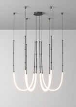 Load image into Gallery viewer, Siliq Sculptural Light with handcrafted silicone forms and metallic segmented cables, single minimalist pendant with glowing silicone tube, dramatic chandelier version of Siliq Light for high ceilings, floor-to-ceiling sculptural lighting installation in modern interior, flexible silicone light tubes emitting soft ambient glow, artistic designer light fixture styled in dining room, contemporary sculptural lighting as statement piece in commercial space.
