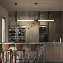 Load image into Gallery viewer, Solari Arc Light with brass arc and linear LED tube, sculptural pendant available in gold or black finish, pair of Solari Arc Lights hanging in modern dining space, minimalist arc pendant styled in office interior, contemporary pendant lighting with sleek LED tube, statement arc light fixture for high ceiling interiors. Modern kitchen with marble island, bar stools, and pendant lights.

