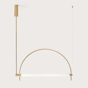 Solari Arc Light with brass arc and linear LED tube, sculptural pendant available in gold or black finish, pair of Solari Arc Lights hanging in modern dining space, minimalist arc pendant styled in office interior, contemporary pendant lighting with sleek LED tube, statement arc light fixture for high ceiling interiors. Gold arch-shaped wall light fixture on a white background