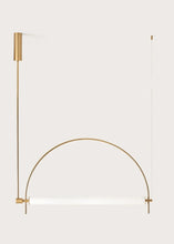 Load image into Gallery viewer, Solari Arc Light with brass arc and linear LED tube, sculptural pendant available in gold or black finish, pair of Solari Arc Lights hanging in modern dining space, minimalist arc pendant styled in office interior, contemporary pendant lighting with sleek LED tube, statement arc light fixture for high ceiling interiors. Modern gold wall-mounted light fixture on a white background
