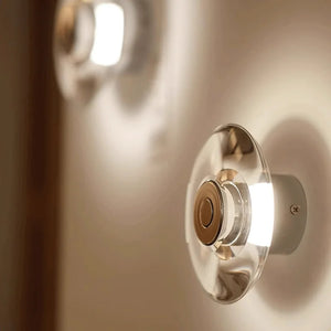 Inspira Lifestyles | Onda Crystal Wall Light with round optical crystal disc and chrome center, mounted as a modern LED wall or ceiling sconce.