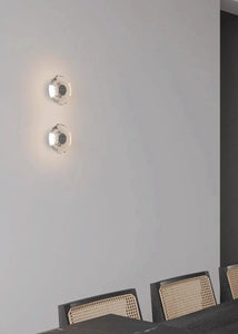 Inspira Lifestyles | Onda Crystal Wall Light with round optical crystal disc and chrome center, mounted as a modern LED wall or ceiling sconce.