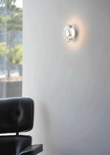 Load image into Gallery viewer, Inspira Lifestyles | Onda Crystal Wall Light with round optical crystal disc and chrome center, mounted as a modern LED wall or ceiling sconce.
