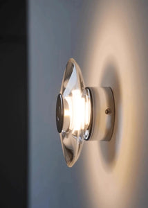 Inspira Lifestyles | Onda Crystal Wall Light with round optical crystal disc and chrome center, mounted as a modern LED wall or ceiling sconce.