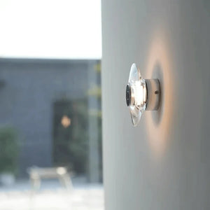 Inspira Lifestyles | Onda Crystal Wall Light with round optical crystal disc and chrome center, mounted as a modern LED wall or ceiling sconce.