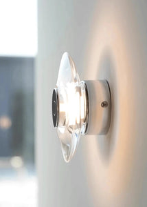 Inspira Lifestyles | Onda Crystal Wall Light with round optical crystal disc and chrome center, mounted as a modern LED wall or ceiling sconce.