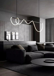 INSPIRA LIFESTYLES | Linear Rope Chandelier - Modern living room with a dark sofa, coffee table, and decorative light fixture.